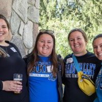 4 Alumnae pose together outside of the Alumni House and Visitor Center